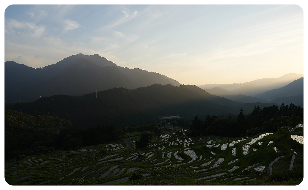 Sony A7 IV Sample image of stepped rice paddies on a mountain side with a valley of vast mountains in the distance 